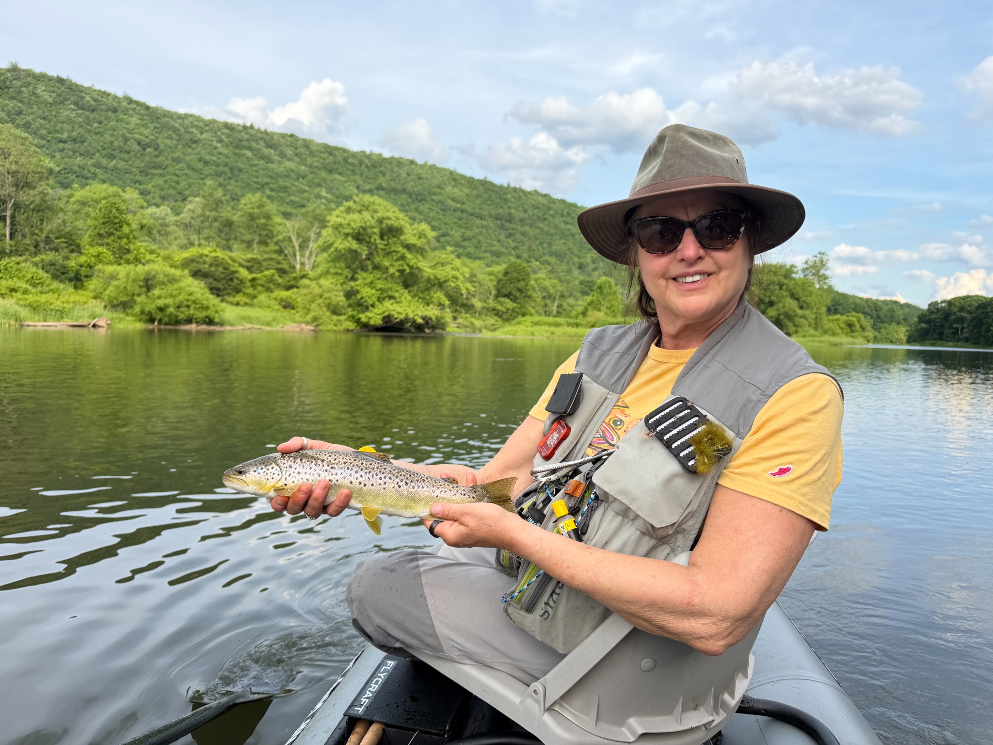 Jill holding a trout while fishing from the Flycraft